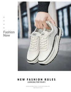 Mano che tiene sneaker in pelle bianca con dettagli testurizzati e design street style