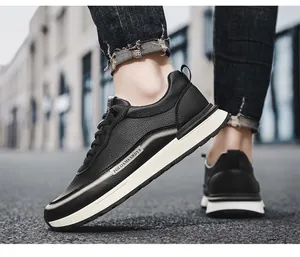 Dettaglio di sneaker in pelle nera con suola bianca indossate da un modello.