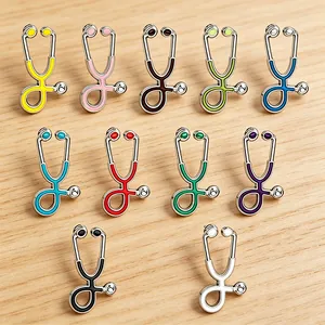 Detailed view of colorful stethoscope enamel pins collection on a light wood background