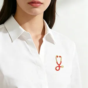 Red and gold stethoscope-shaped enamel brooch pinned on a white professional shirt