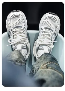 Detalle de vista superior de zapatillas deportivas de malla blanca con vaqueros azules