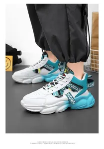 Detail view of men's chunky sneakers with white and teal color-blocking design