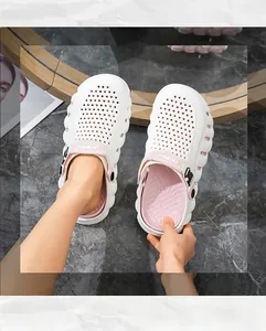 Detailansicht der weißen Badeschuhe mit dicker Sohle, rosa Futter und Belüftungslöchern.