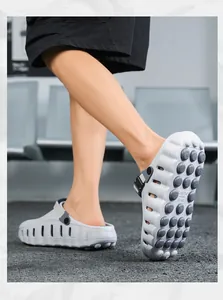 Detailansicht graue Clogs mit dicker Sohle und rutschfester strukturierter Sohle.