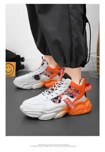 Detailed view of men's mid-top platform sneakers in vibrant white and orange leather.