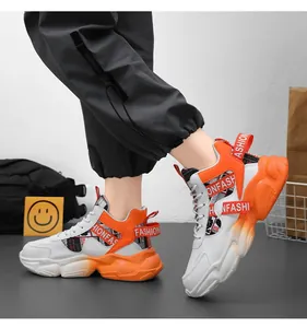 Side view detail of trendy white and orange platform basketball shoes on model