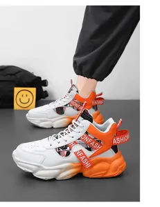 Side view of white and orange mid-top chunky sneakers with 'FASHION' strap details