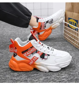 Close-up of men's chunky orange and white high-top sneakers with height increasing soles