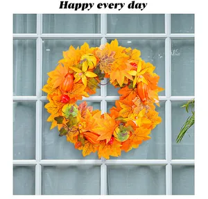Macro view of artificial autumn wreath featuring maple leaves and pumpkins on a window frame