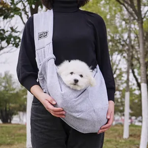 Dichtbij van een grijze comfortabele schoudertas voor huisdieren met een kleine witte hond