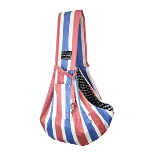Detail of red and blue striped pet sling bag featuring gingham lining and a woven label