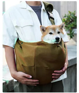 Close-up detail of breathable pet carrier sling with adjustable strap holding a dog.