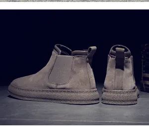 Rear view of men's suede Chelsea boots with thick textured sole and elastic panels.