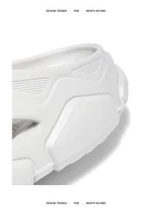 Nahaufnahme der strukturierten dicken Sohle und des weißen Mech-Designs der Slipper