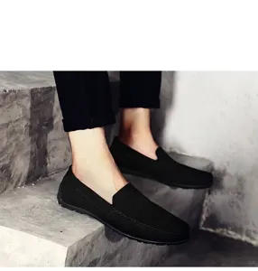 Vue détaillée de mocassins en daim noir pour hommes sur des escaliers en béton