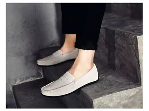 Gros plan de mocassins en daim gris clair pour hommes portés sur des escaliers