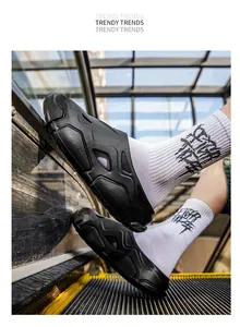 Nahaufnahme von schwarzen futuristischen Mecha-Slippern auf einer Rolltreppe.