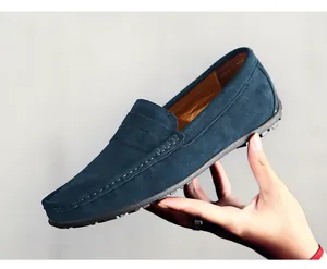 Détail rapproché montrant la matière en daim bleu marine et les coutures des mocassins pour hommes