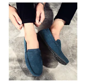 Gros plan de mocassins en daim bleu sur modèle avec détails de couture mocassin.