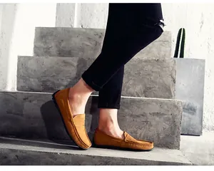 Gros plan détaillé de mocassins en daim marron pour hommes sur des marches en béton brut