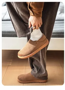 Détail de chaussures sans lacets en daim marron pour hommes dans un intérieur douillet