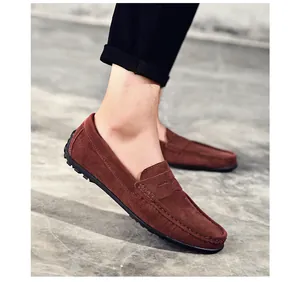 Gros plan détaillé des mocassins homme en daim marron montrant la texture et coutures