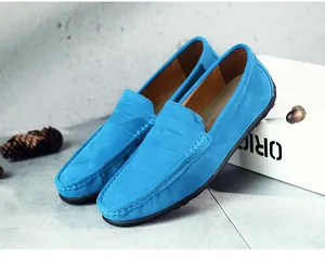 Gros plan de mocassins en daim bleu vif avec coutures mocassins sur fond de béton gris