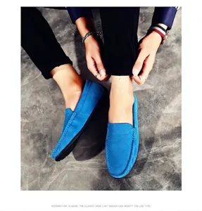Vue détaillée de mocassins en daim bleu pour hommes sur un sol en pierre grise
