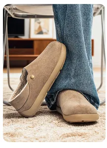 Détail de sabots pour hommes en daim beige avec doublure en peluche et semelle épaisse.