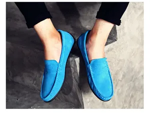 Vue détaillée de haute qualité de mocassins en daim bleu vif pour hommes élégants sur béton
