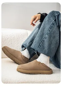 Vue détaillée de sabots en daim kaki portés avec des chaussettes blanches et un jean.