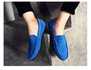 Mocassins en daim bleu vif pour hommes stylisés sur des marches en béton gris clair