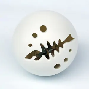 Primer plano de una pelota de juguete luminosa blanca para gatos con diseño de espina
