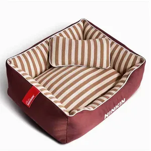 Detail view of a striped rectangular dog bed with matching pillow and NINKIN brand tag