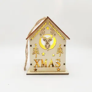 Close-up of a warm glowing wooden Christmas house ornament with XMAS carving detail