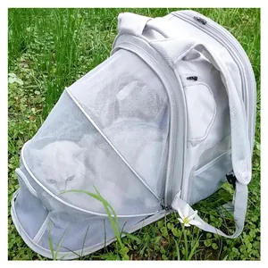 Portable gray expandable cat carrier backpack with breathable mesh on green grass