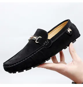 Close-up view of black suede loafers showing elegant metal buckle and textured material