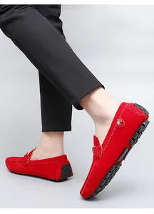 Detailed close-up view of vibrant red suede men's loafers featuring a gold side ornament