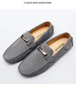 Close-up view of grey suede slip-on loafers featuring a stylish metal buckle