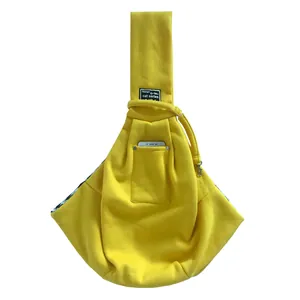 Detail view of a yellow pet sling carrier bag with a convenient front phone pocket.