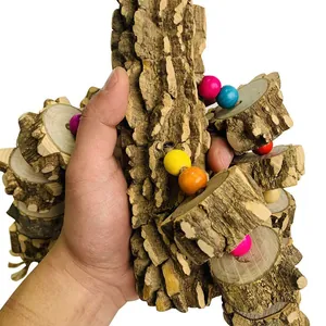 Hand holding a natural wood parrot chew toy with colorful beads for bird cages
