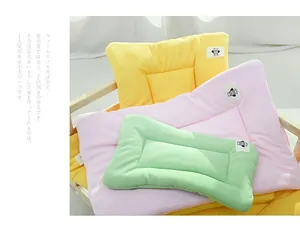 Close-up view of stacked pastel waffle-texture pet mats in pink, yellow and green colors.
