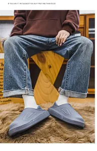 Detailansicht blauer wasserdichter Herren-Hausschuhe mit warmem Futter auf einem Teppich.