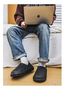 Lifestyle-Detailansicht von isolierten schwarzen Herren-Winterhausschuhen für das Haus.