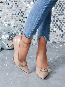 Détail de chaussures beiges à bout pointu avec texture crocodile et boucle argentée chic