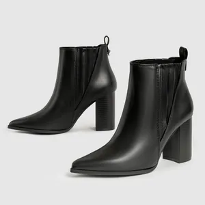 Professionele detailopname van zwarte Chelsea boots met spitse neus en hoge blokhakken