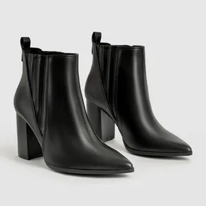 Professionele detailopname van elegante zwarte Chelsea boots met spitse neus en hoge blokhak