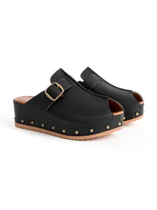 Gros plan de mules noires à plateforme avec bout ouvert, boucle et clous décoratifs