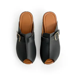 Vue de dessus de sabots noirs élégants avec boucle dorée et semelle marron
