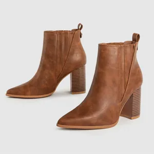 Detailweergave van elegante bruine Chelsea boots met puntneus en een stijlvolle blokhak.